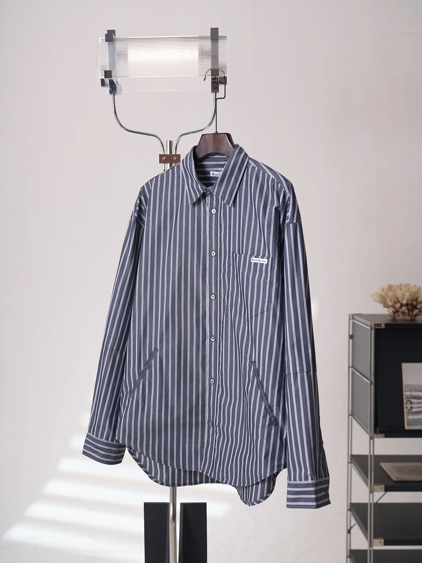 [Real auction] Acne Studios logo double-sleeved striped long-sleeved shirt [In Stock] 44 46 48 50 Customized matte woven combed poplin, crisp and stylish, comfortable and close to the skin, misty charcoal blue interwoven with pure white vertical stripes, between the rising and falling lines, revealing the cool and relaxed style of Scandinavia. Cleverly created layered double-sleeved deconstructed tailoring, breaking the inherent paradigm of traditional shirts, giving the body staggered three-dimensional layers. The iconic stripes of the season are laid out vertically. Rhythm runs through the entire garment. The left chest pocket is embellished with the Acne Studios logo. The brand context is engraved in the square dimensions. The side seams are equipped with wide welt pockets. Integrating styling aesthetics and practical functions. Adhering to the high-end aesthetics of minimalism. Pioneer ingenuity returns to daily life. It interprets the Nordic ready-to-wear attitude of symbiosis of relaxation and sophistication. Infrared positioning cutting machine uses infrared emitters and infrared receivers to achieve precise positioning of materials. The accuracy can reach the micron level. So as to meet the effect of high-precision cutting of plaid alignment. Manual infrared line drawing pockets are assisted by infrared technology to achieve precise positioning and marking of pocket positions, which retains the fineness and flexibility of hand sewing. It adopts side-turning embedded stitching technology to provide high-quality stitching results. Smooth and tidy. The fabrics have been sand washed and have a better hand feel. Not easy to deform, not easy to shrink, not easy to fade, and maintain long-term beauty and loose fit.